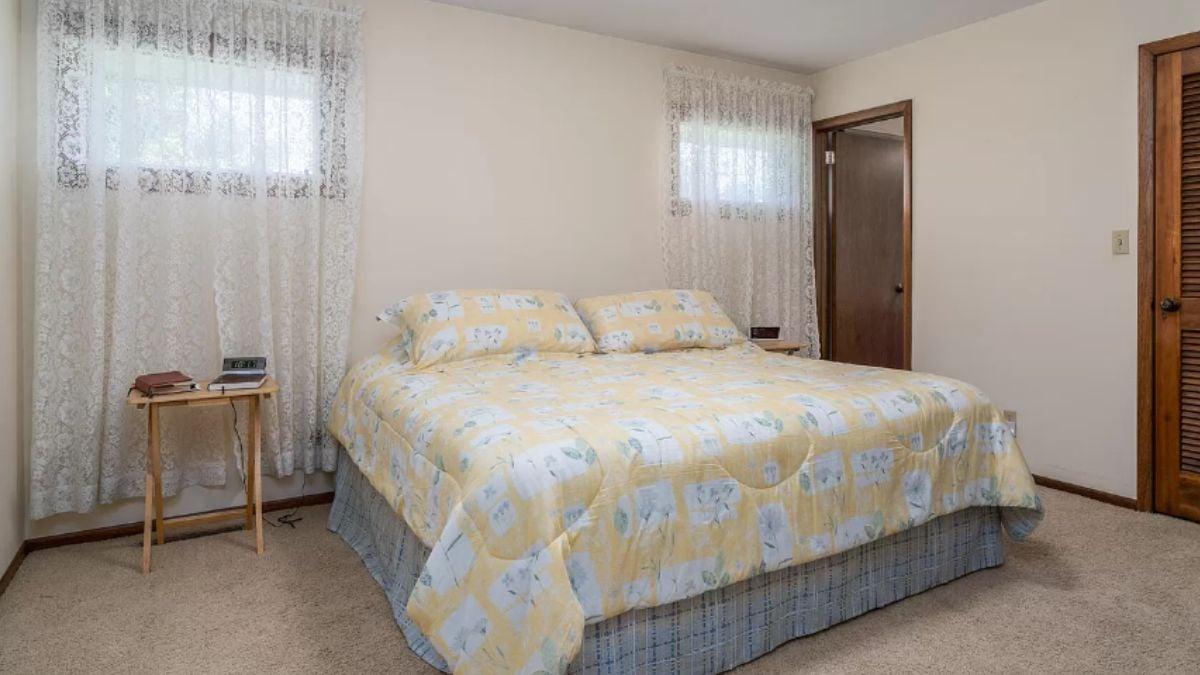 Vintage Bedroom with Floral Bedspread and Lace Curtains