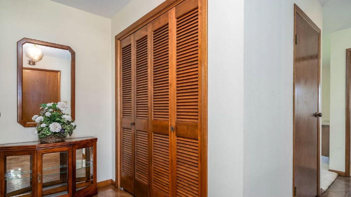 Hallway Charm with Louvered Closet Doors and a Vintage Touch