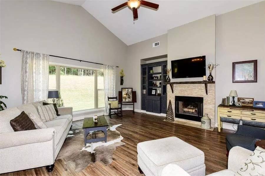 Vaulted Living Room with Elegant Fireplace and Built-In Shelves