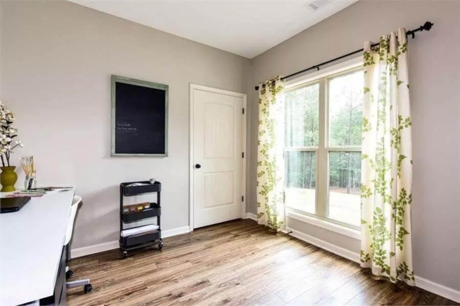 Sunlit Home Office with Floral Curtains and Hardwood Floors