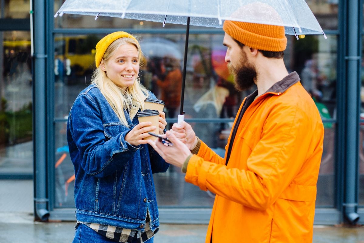Woman apologize to her boyfriend with cup of coffee.