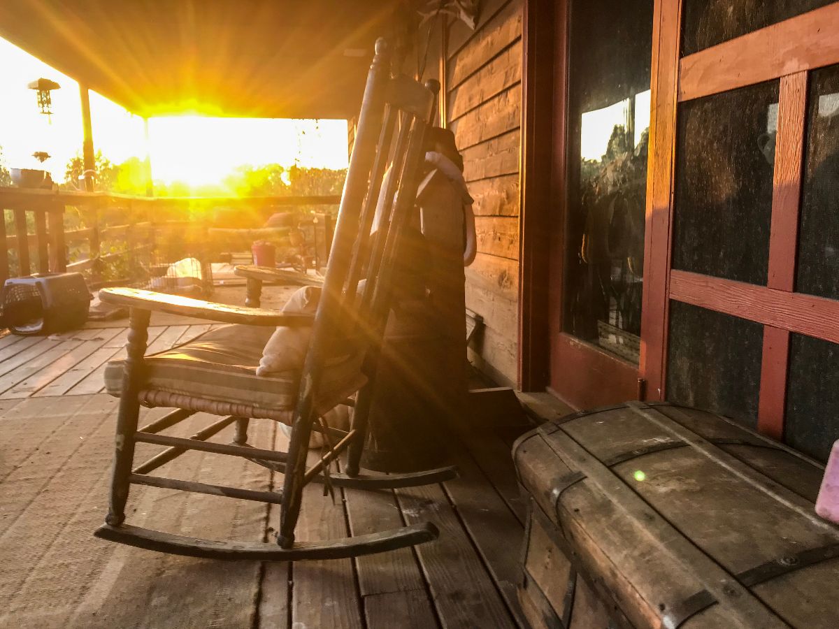 Autumn Country front porch with rocking chair at sunset.