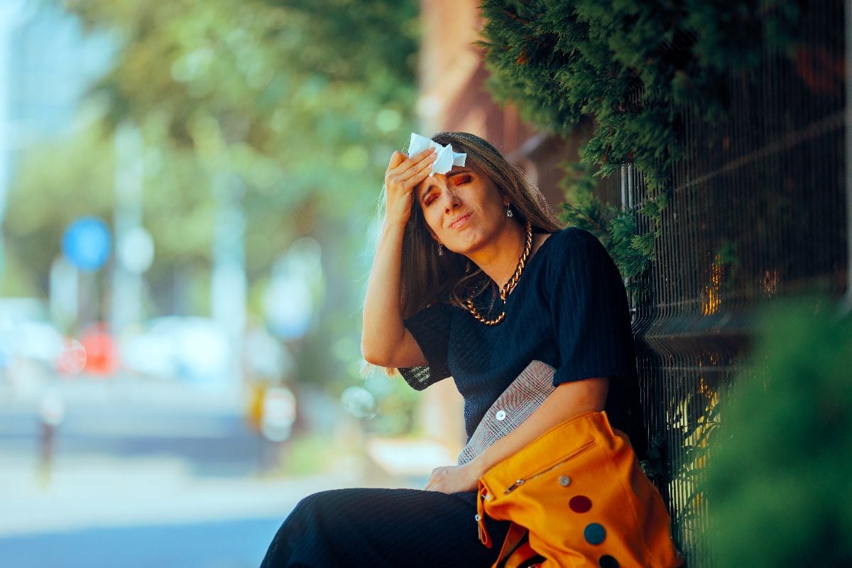 Woman suffering during hot summer outdoors.