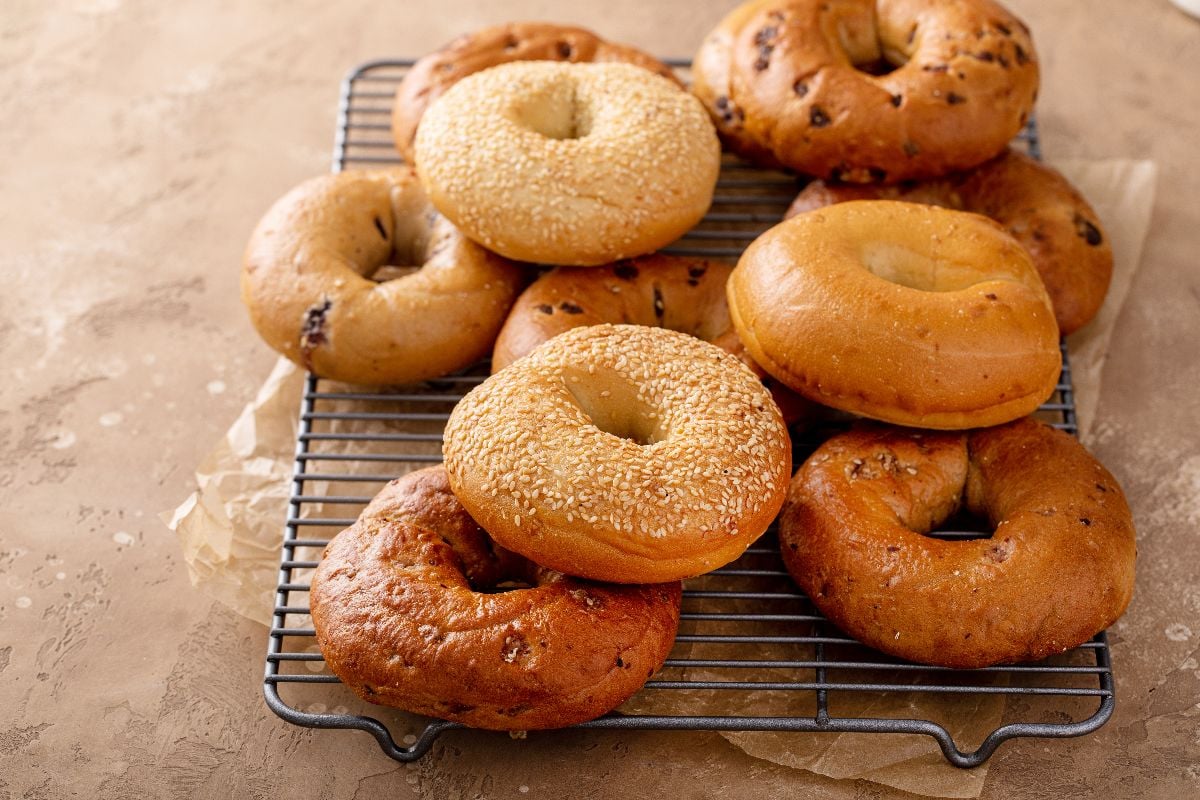 Freshly baked bagels on a rack.