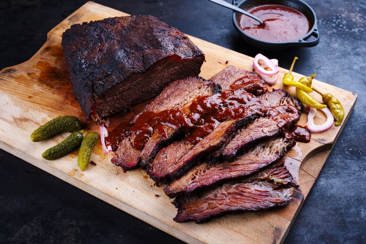 Traditional smoked wagyu beef brisket served with vegetable and spicy barbecue Louisiana sauce.