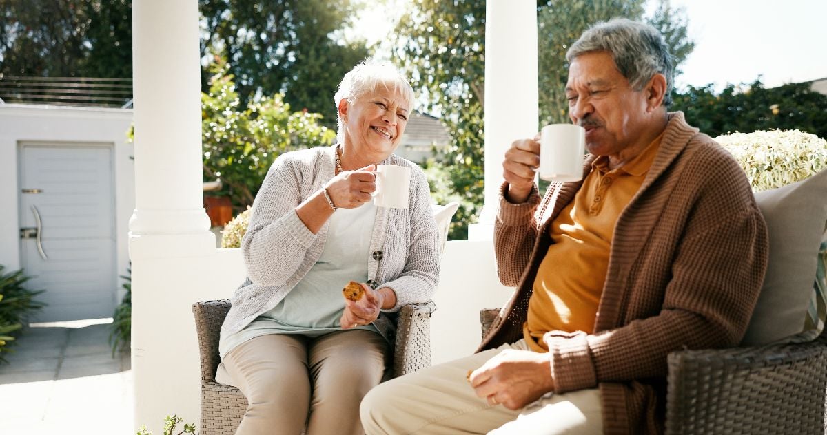 Old couple bonding and having coffee in the porch.