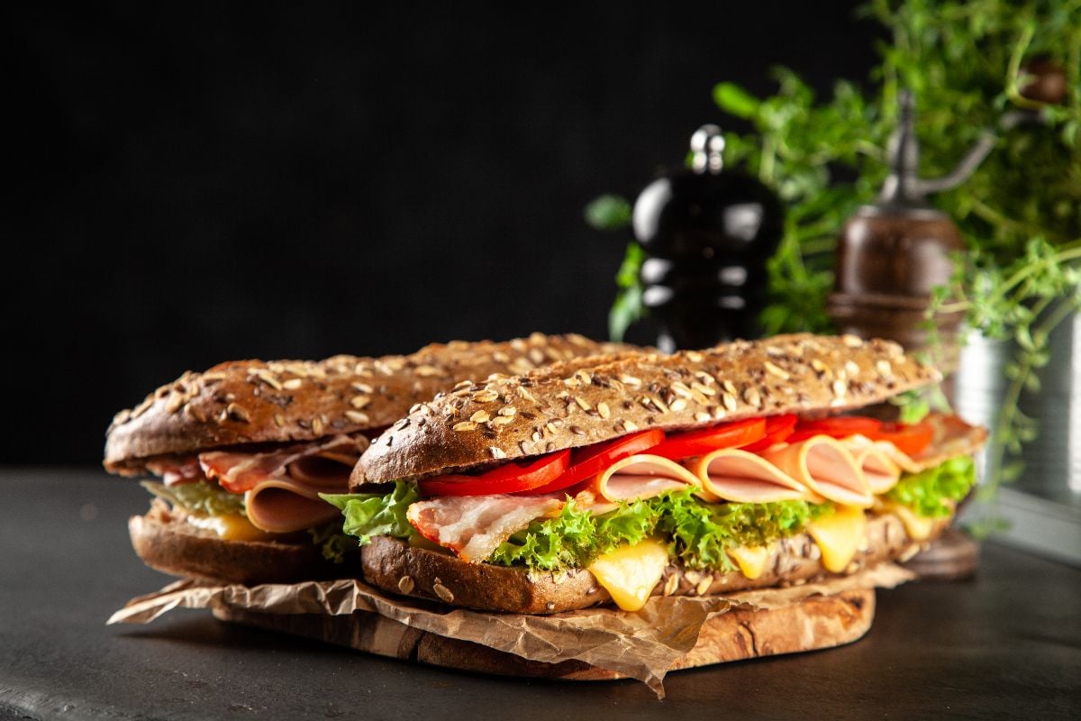 A couple of classic BLT sandwiches on the black table.