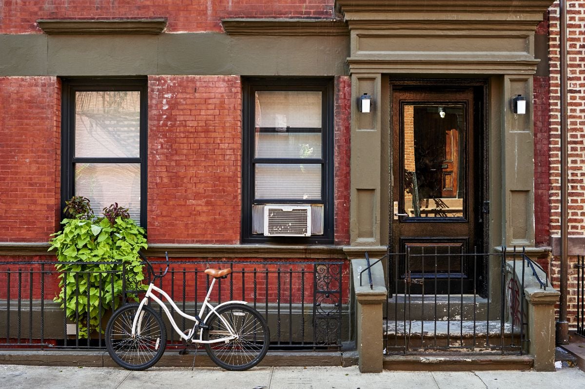 A bicycle in front of a brownstone building.