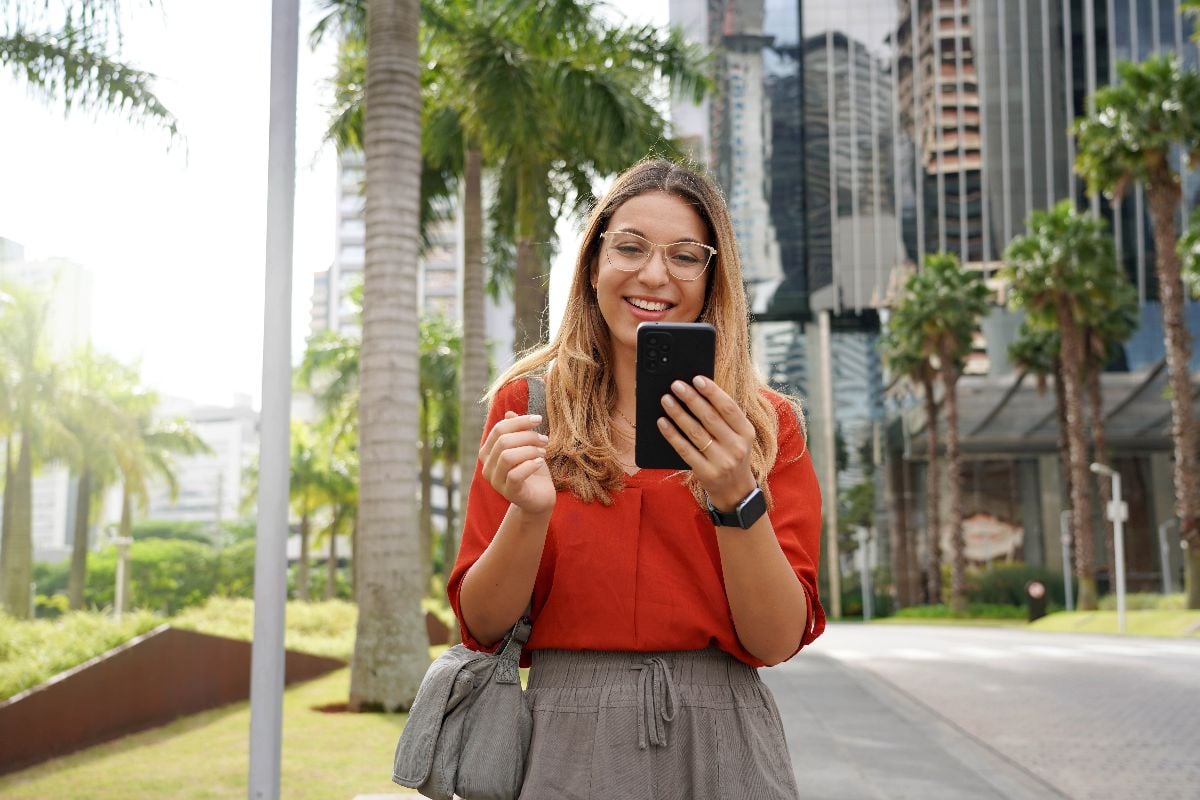 Businesswoman using phone outside office.