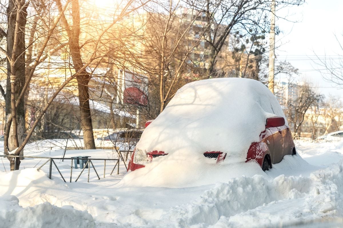 Car buried in snow drift.