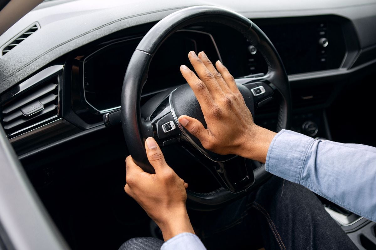 Young man honking while driving.