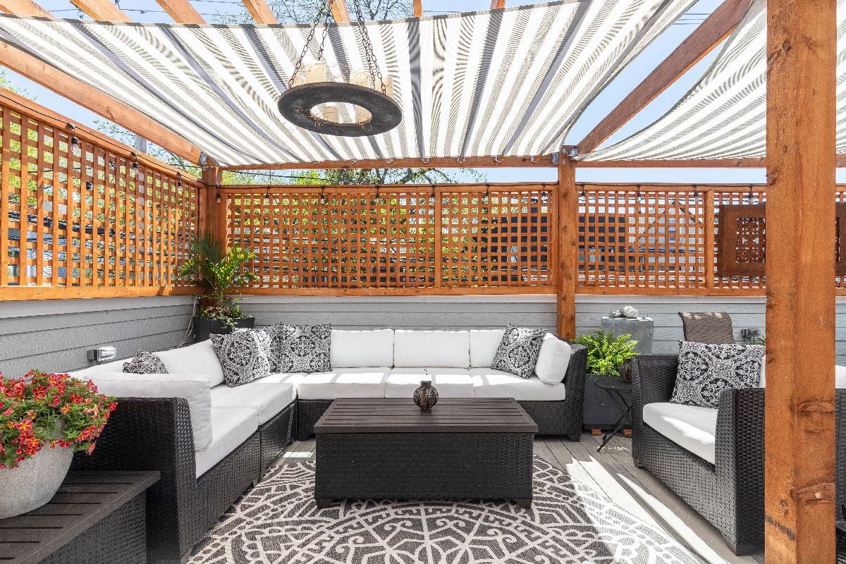 A cozy rooftop patio with covered pergolas over the top.