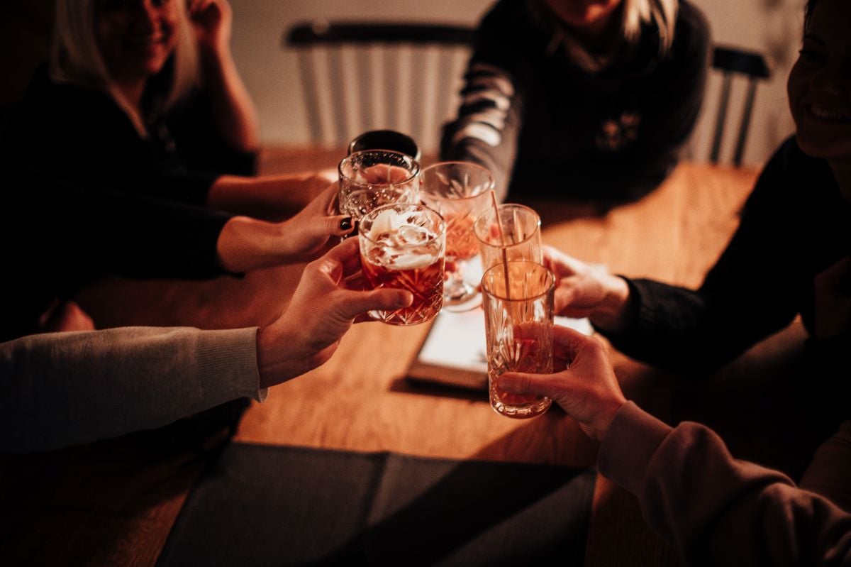Close-up of friends clinking glasses in a cozy atmosphere.