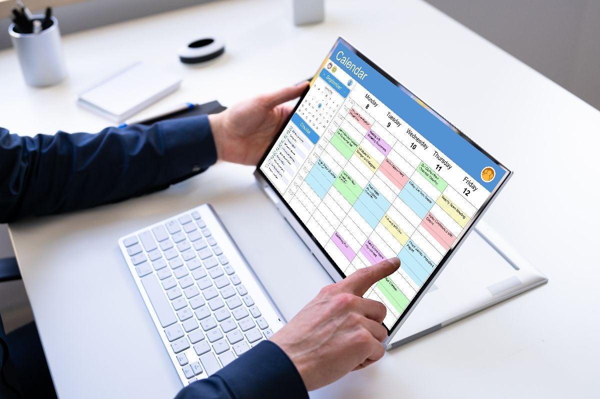 Appointment schedule planner and date calendar on hybrid laptop.