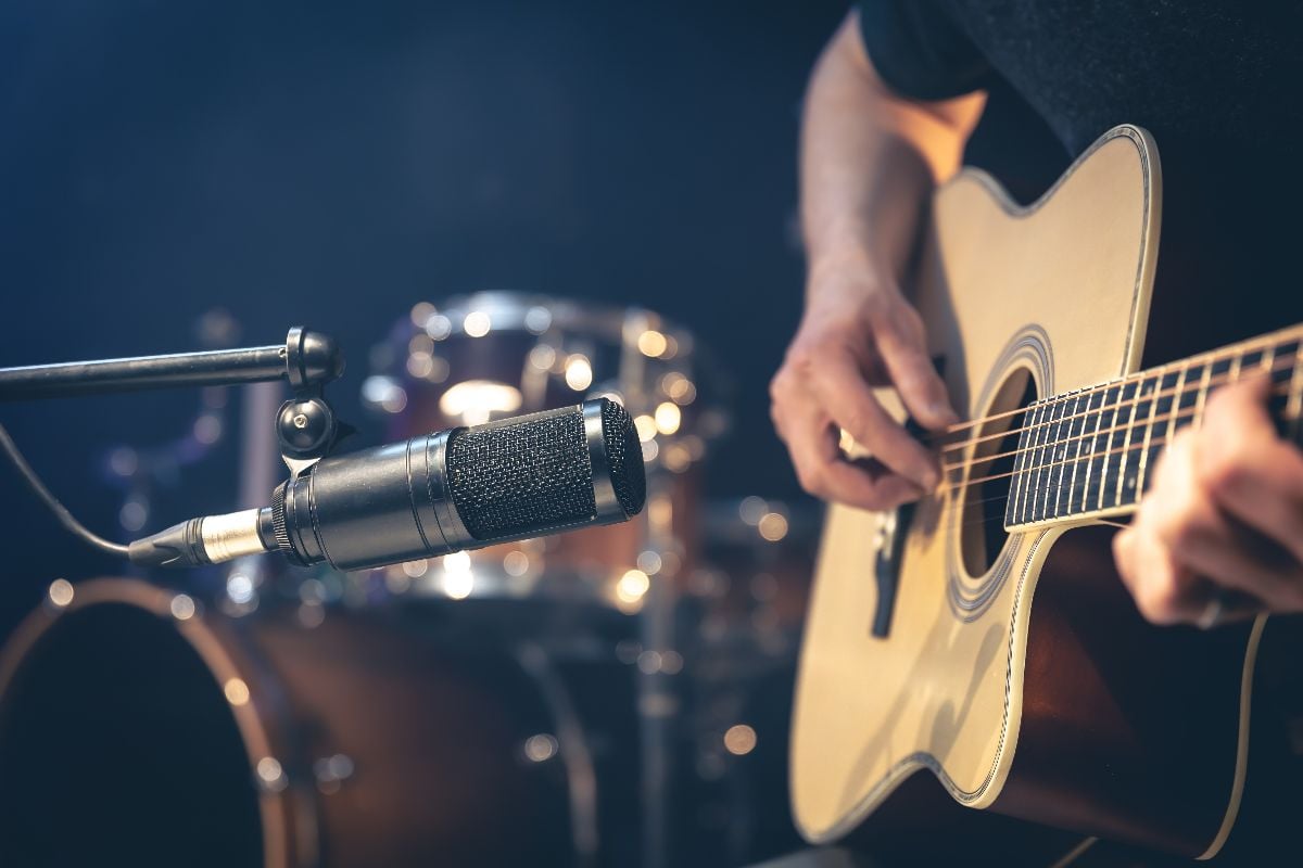 Musician playing acoustic guitar.