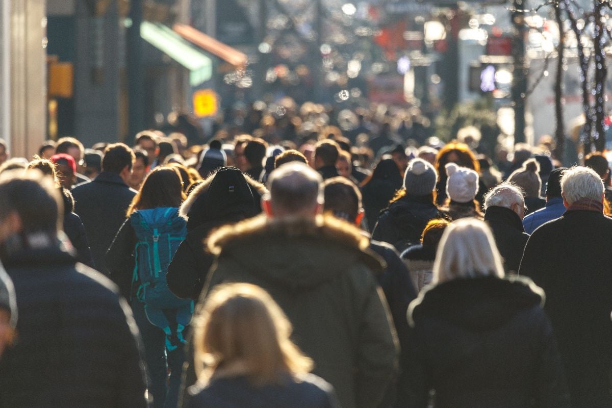 Crowd of people walking on a street in New York City.