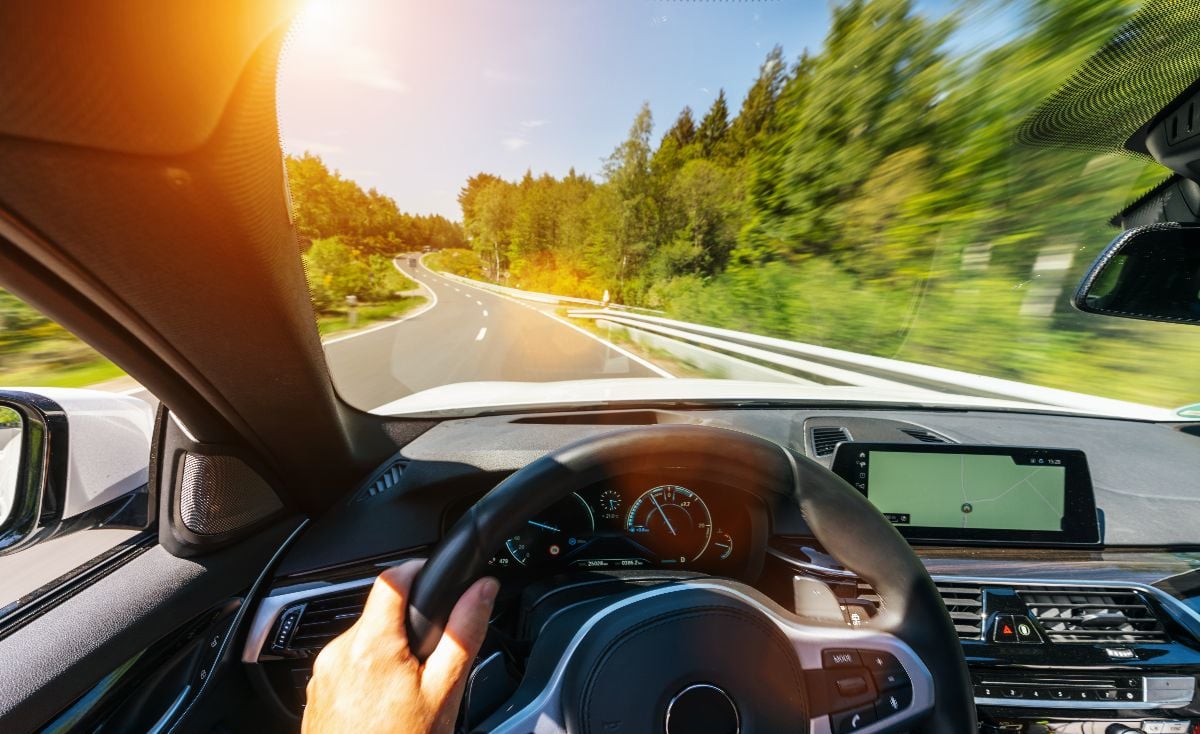 Hands of driver on steering wheel.