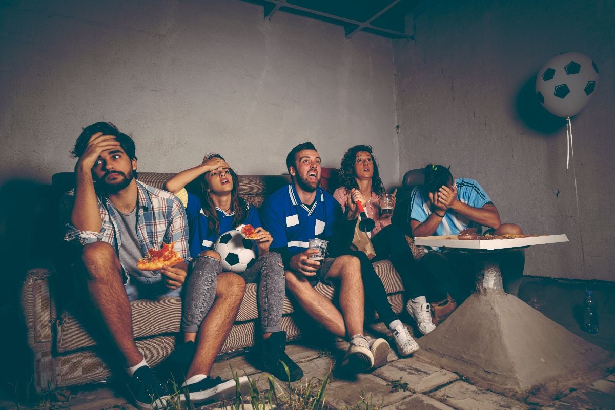 Friends watching football game with disappointed faces.