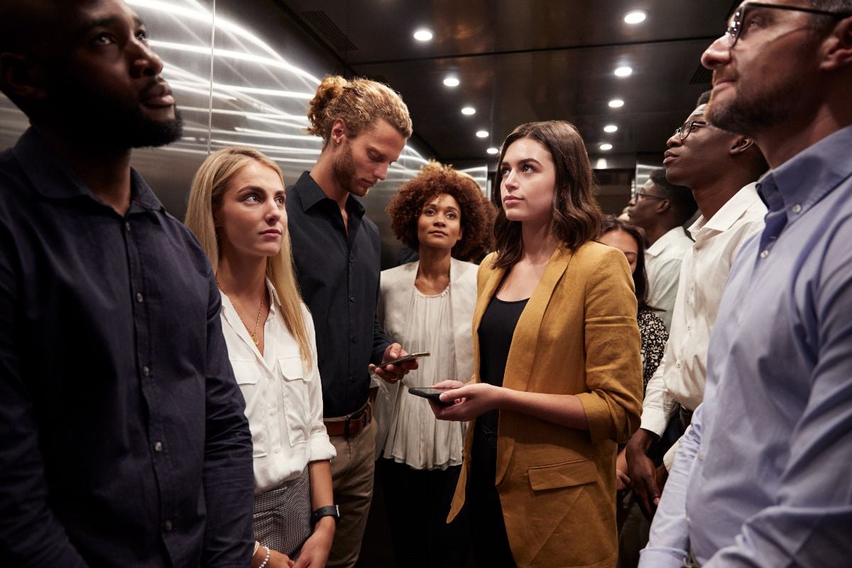 Work colleagues not talking inside the elevator.