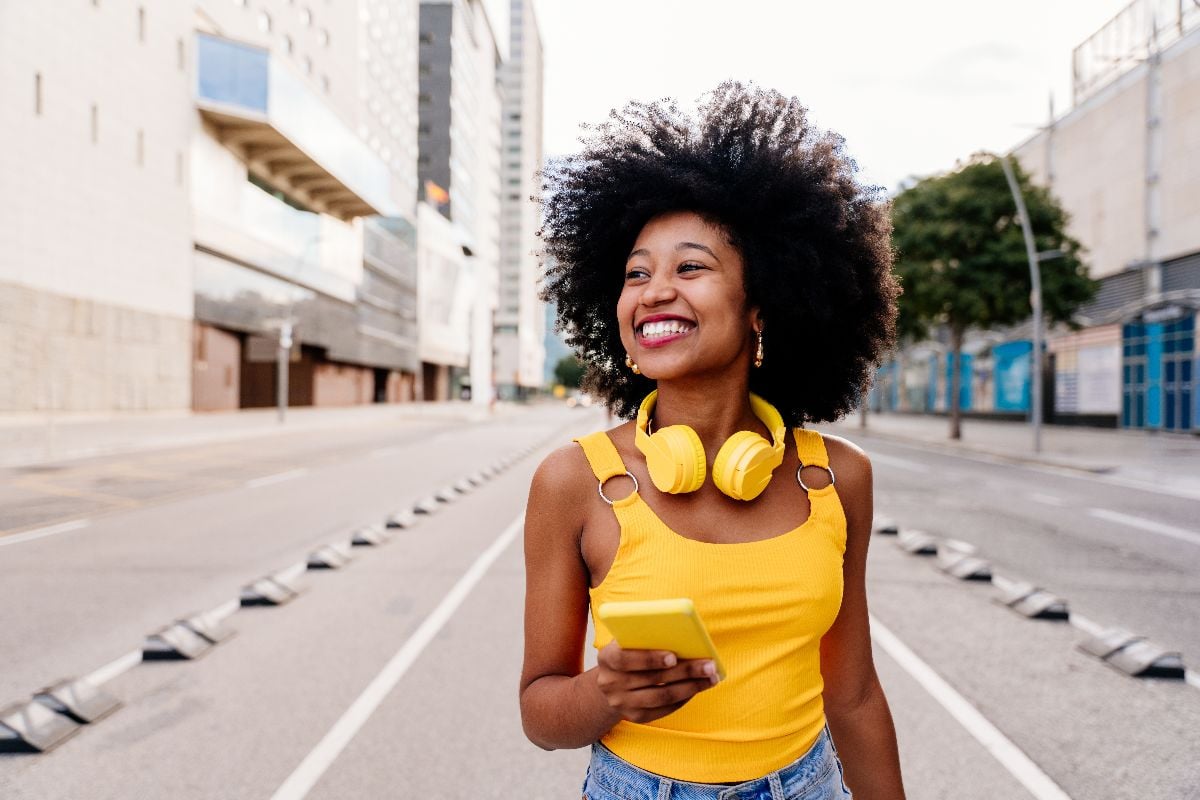 Woman in yellow top strolling in the city.