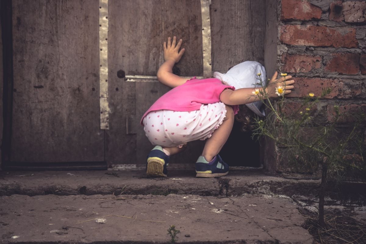 Curious child looking into an abandoned house.