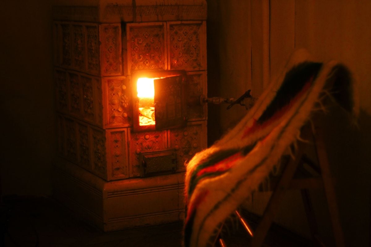 Fireplace and a chair covered in blanket.