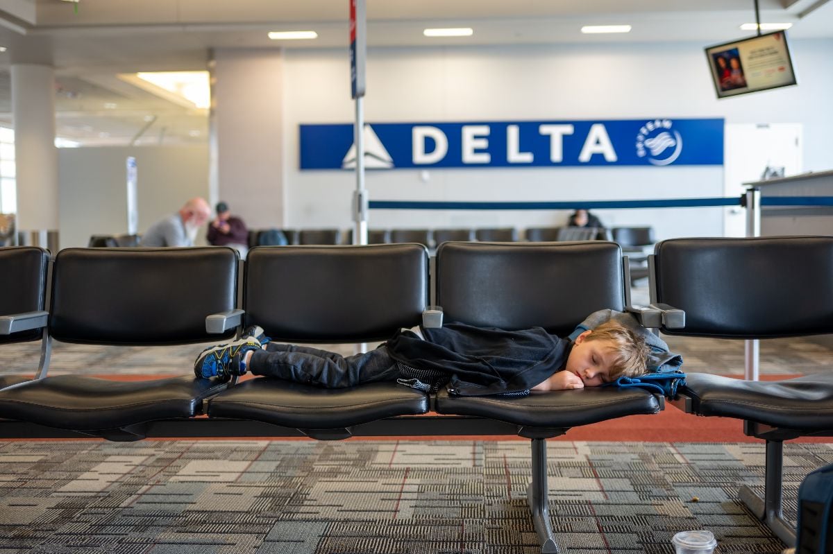 A child sleeping on a row of chairs at the O'Hare Airport Delta Terminal.