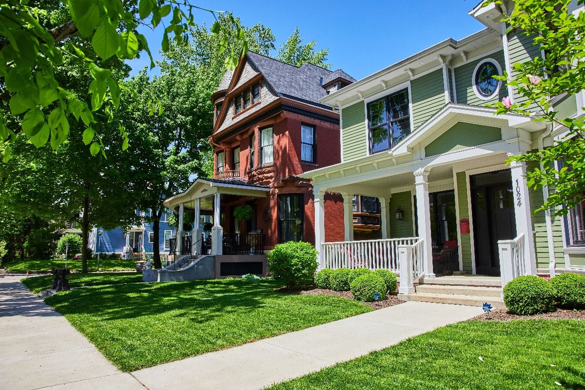 Street view of Victorian and modern suburban homes.