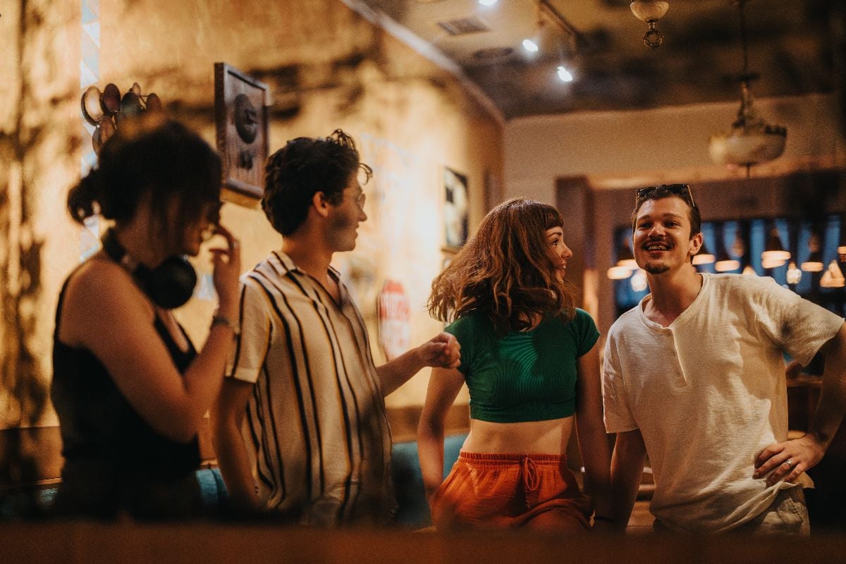 A group of young friends laughing and chatting in a cafe.