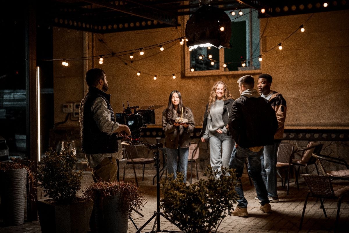 Group of friends filming a scene in an outdoor setting at night.