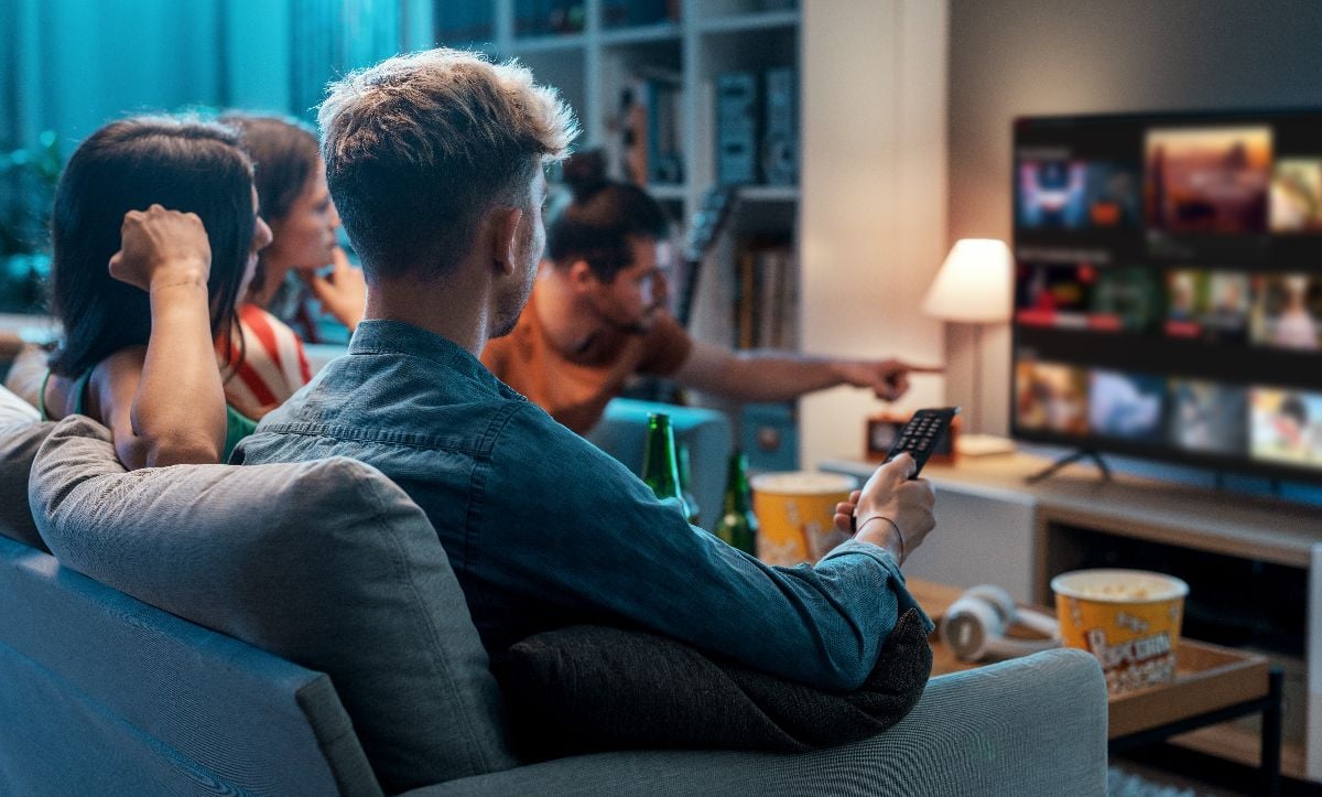 Friends watching movie inside the apartment.