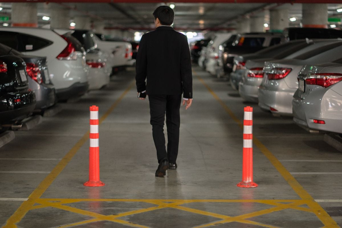 Man looking for his car inside the parking lot.