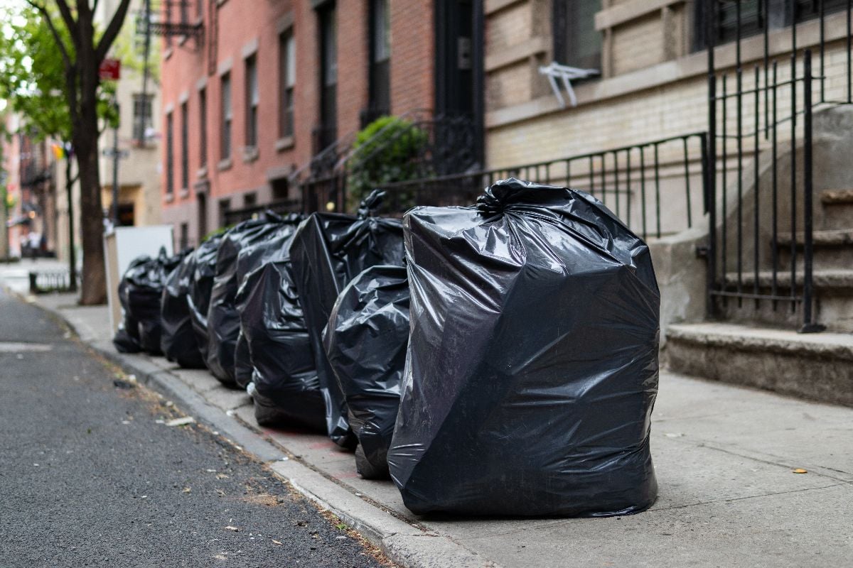 Black garbage bags along a residential street in Greenwich Village of New York City.