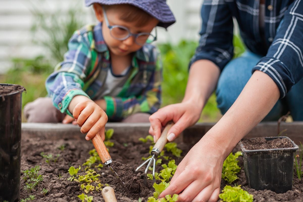 Little girl helping her mother in gardening.