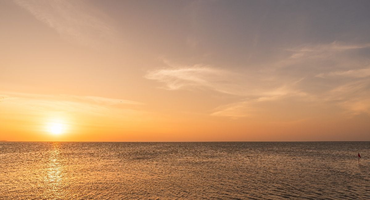 Sunset sky clouds over sea in the evening.