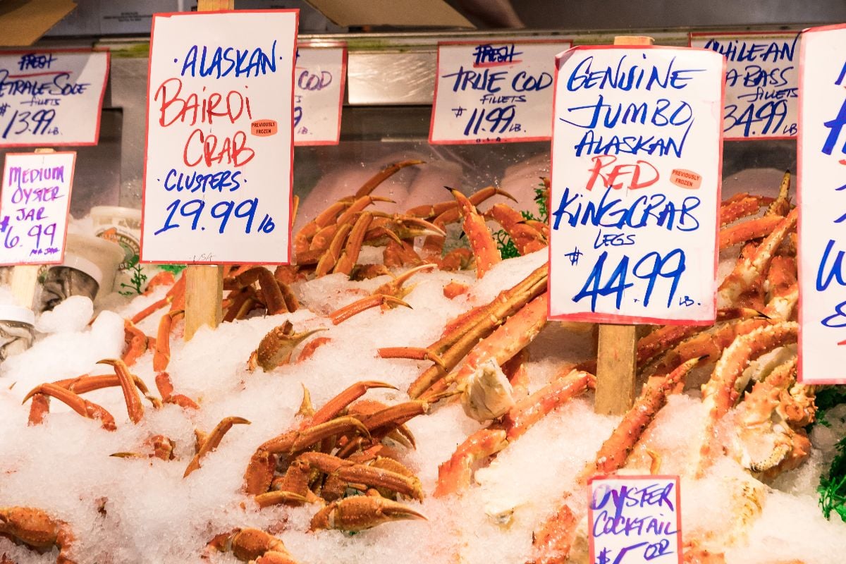 Close up of Alaskan Bairdi Crab and Genuine Jumbo Alaskan Red King crab legs on ice display.