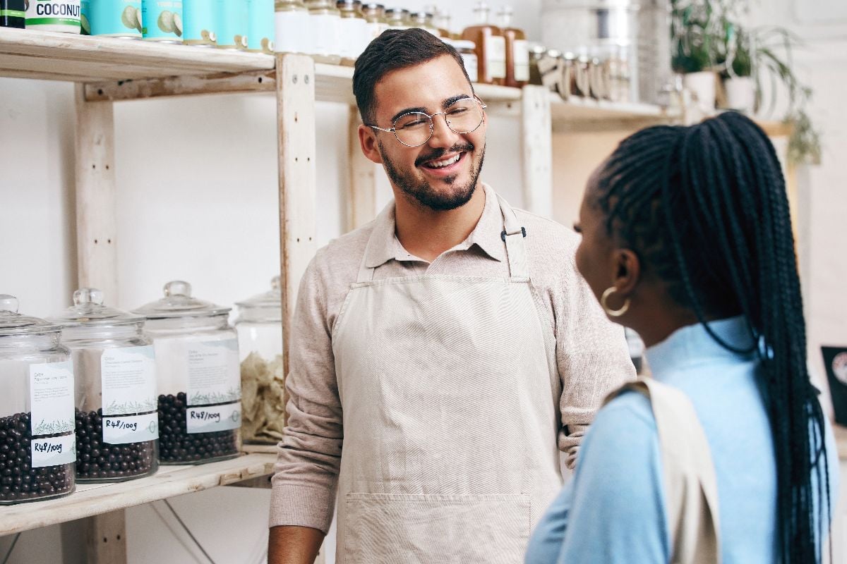 Staff and costumer in a friendly conversation at a grocery store.