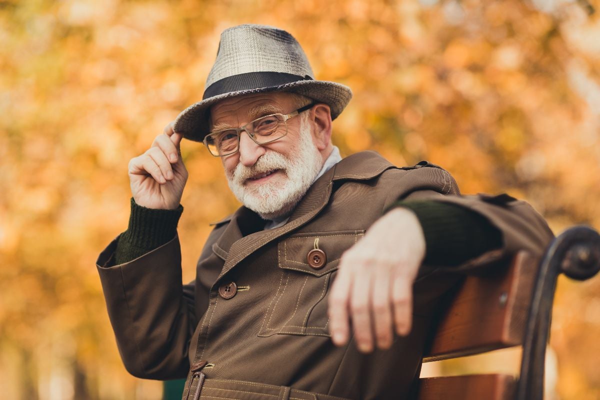 Grandpa sitting on the bench and greeting with a head nod.