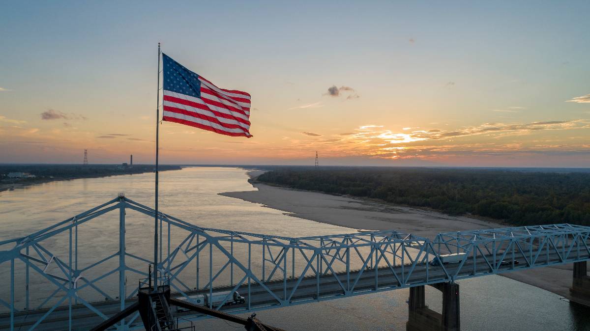 American flag on top of the old highway 80 bridge crossing over the Mississippi River.