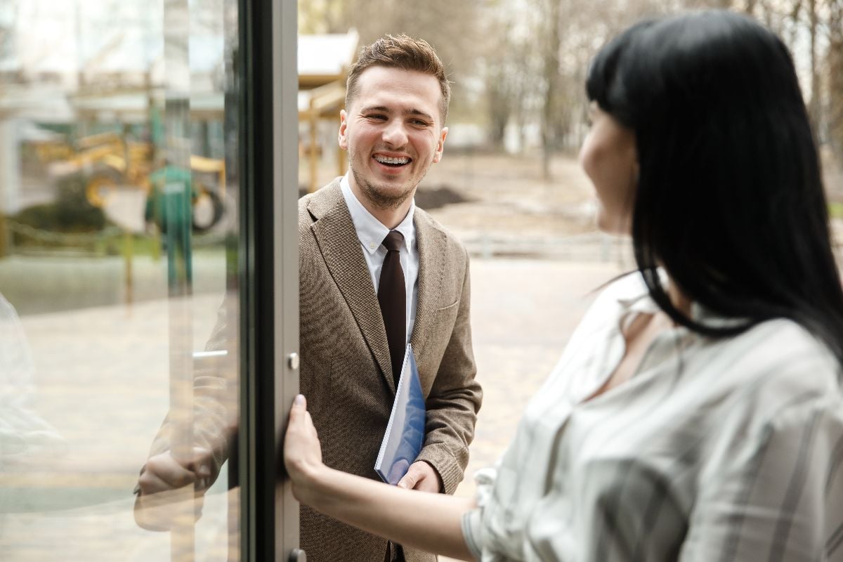 A man holding the door for the woman.