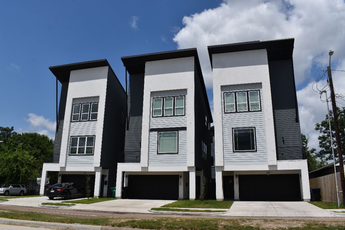 A portrait of a residential property consisting of three buildings.