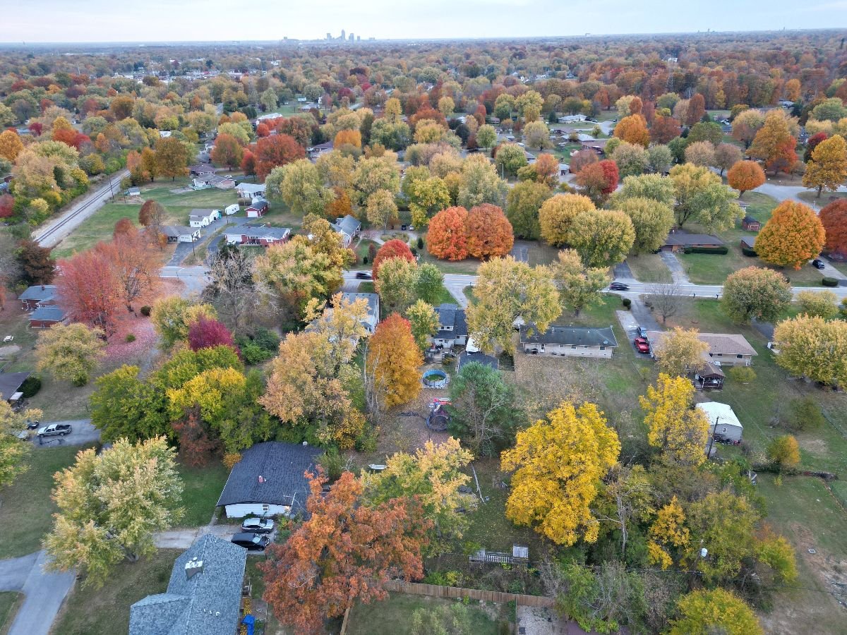 Aerial view of Indianapolis neighborhood surrounded by colorful autumn trees.
