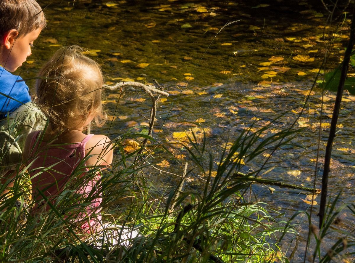 Two kids playing in the creek.
