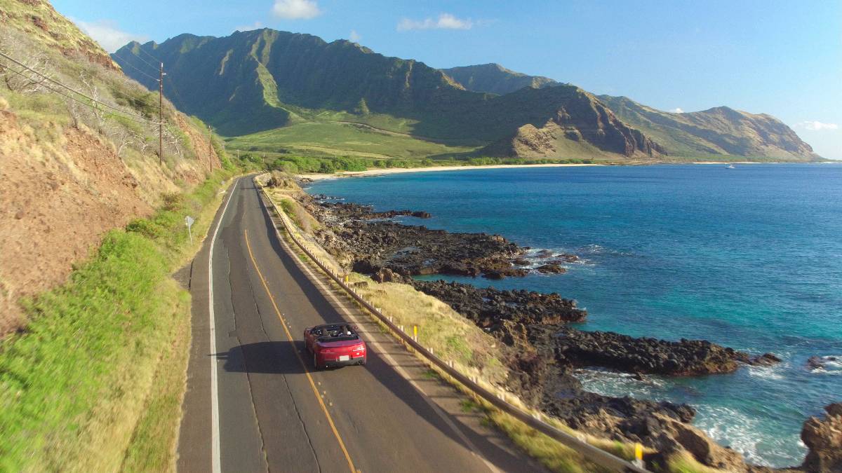 Aerial view of a car driving along the picturesque coastal road.