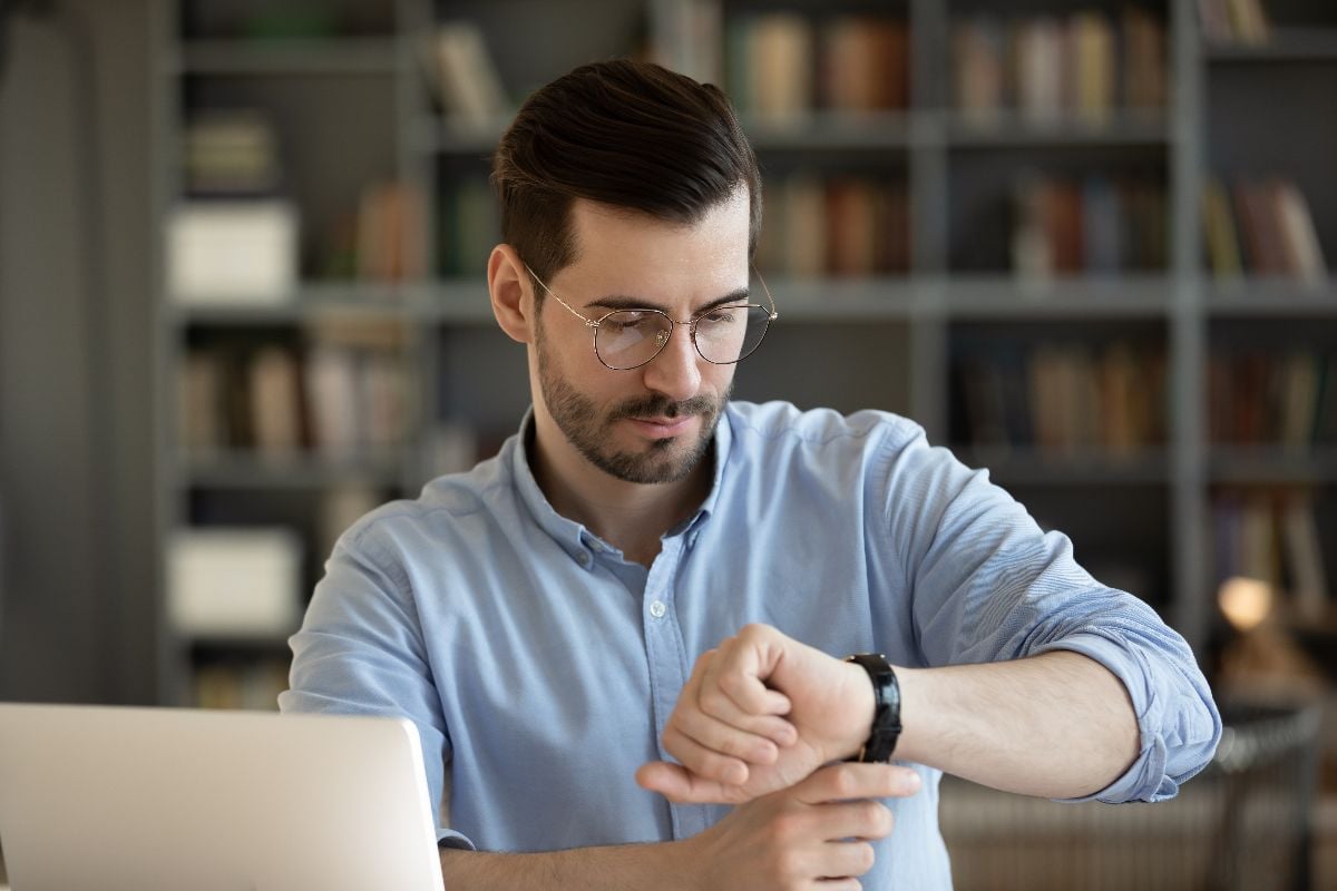 Businessman checking on time in his watch.