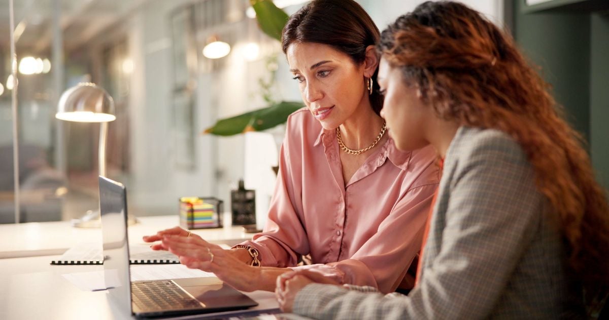 Two businesswomen discussing with a laptop.
