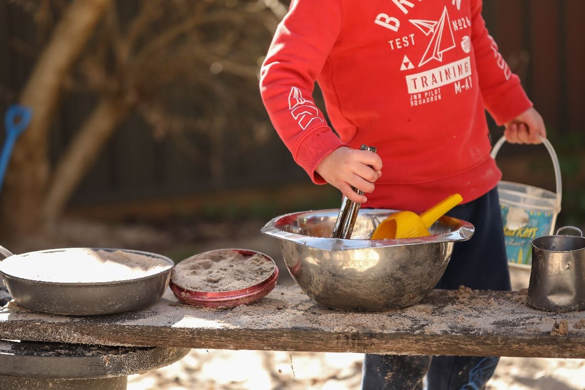 Boy making a mud pie.