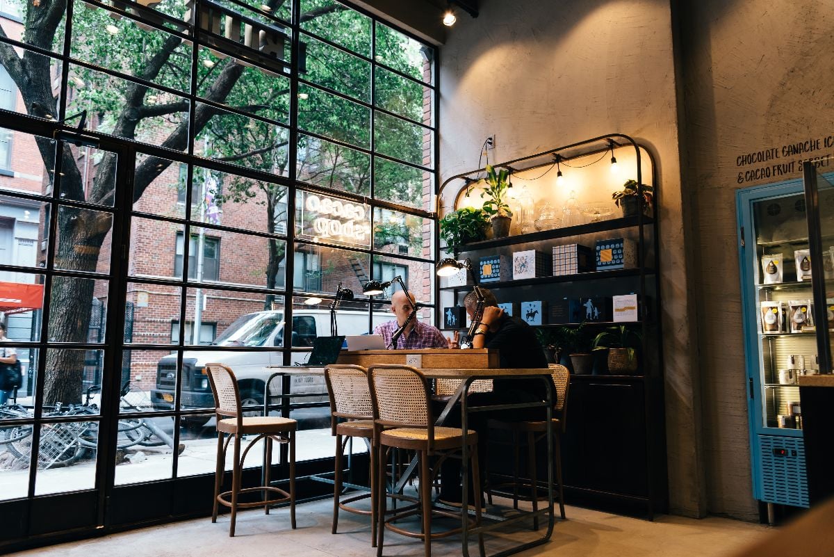 A couple of male professionals working at table at a cafe.