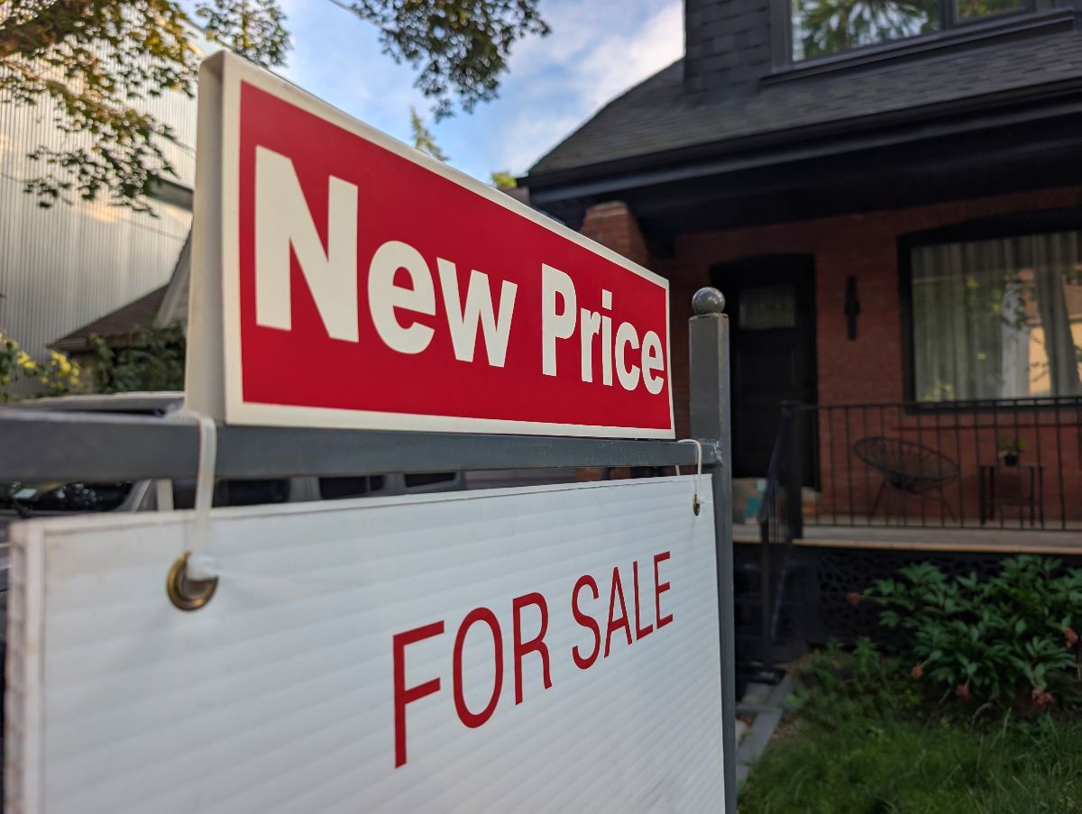 New Price and For Sale signage in front of the house.
