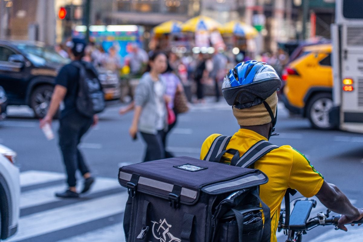 Food delivery driver riding a bicycle in the streets of New York.